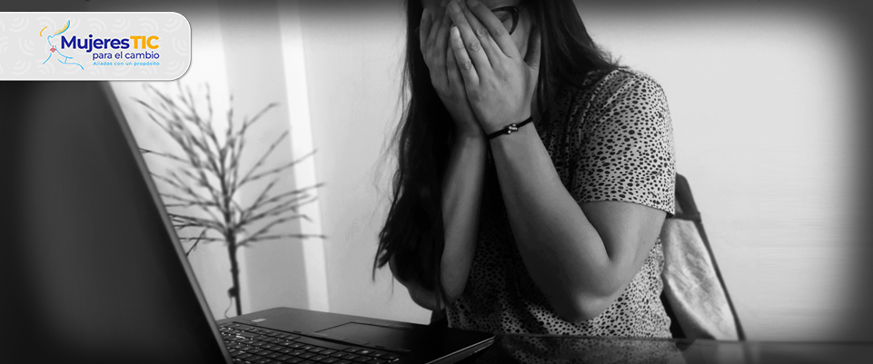 mujer frente al computador con las manos en la cara en señal de angustia