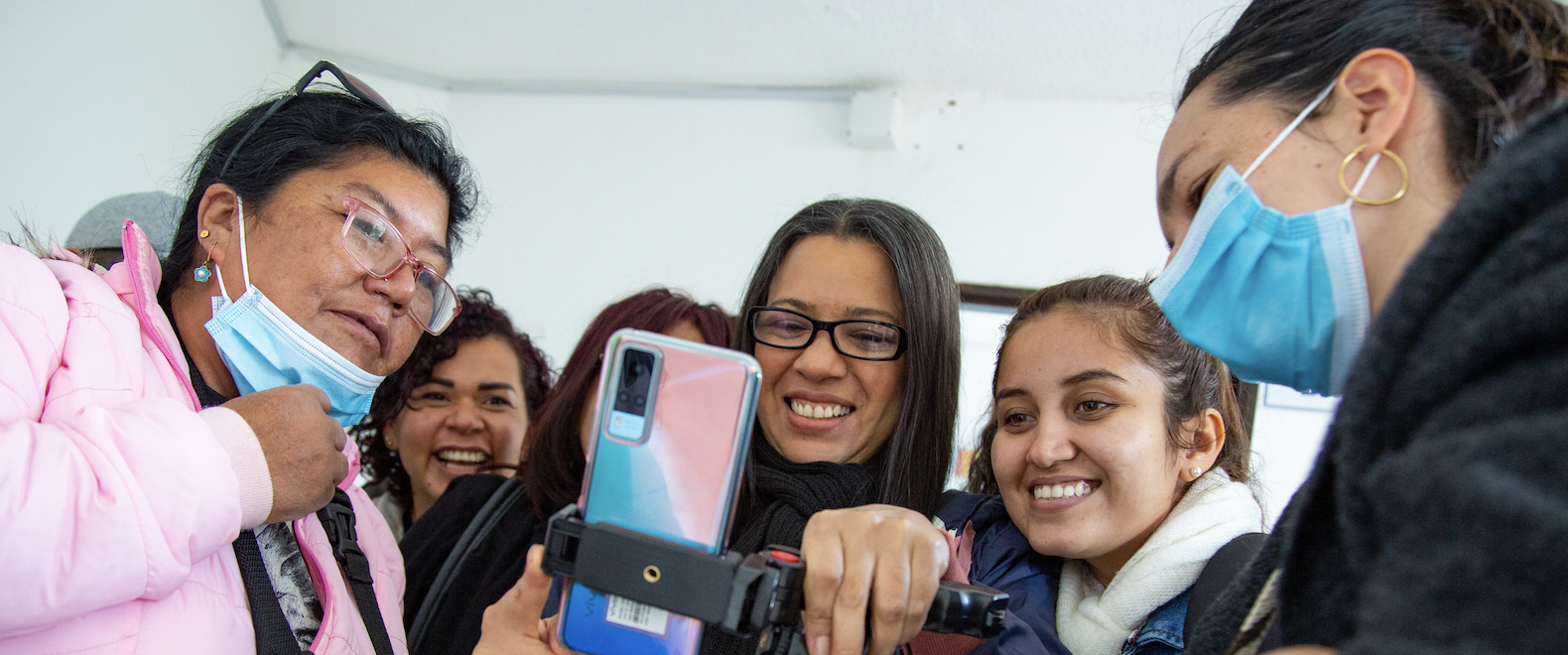 Mujeres sonriendo con un celular