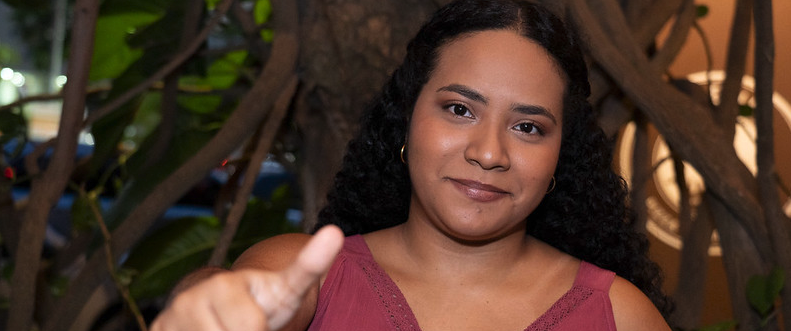 Mujer sonriente haciendo señal de aprobación con su mano