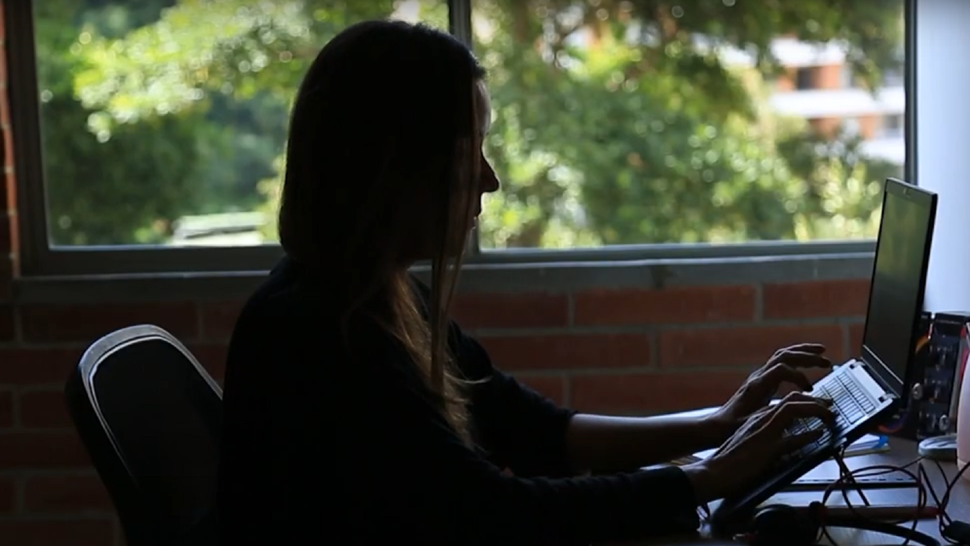 Una mujer trabajando en una oficina con un computador